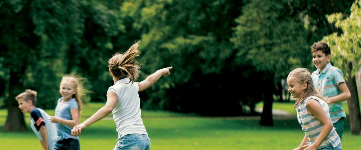 Kinder spielen gemeinsam draußen auf einer Wiese